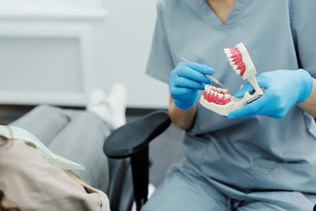 odontologista-com-implante-dentario-na-mao