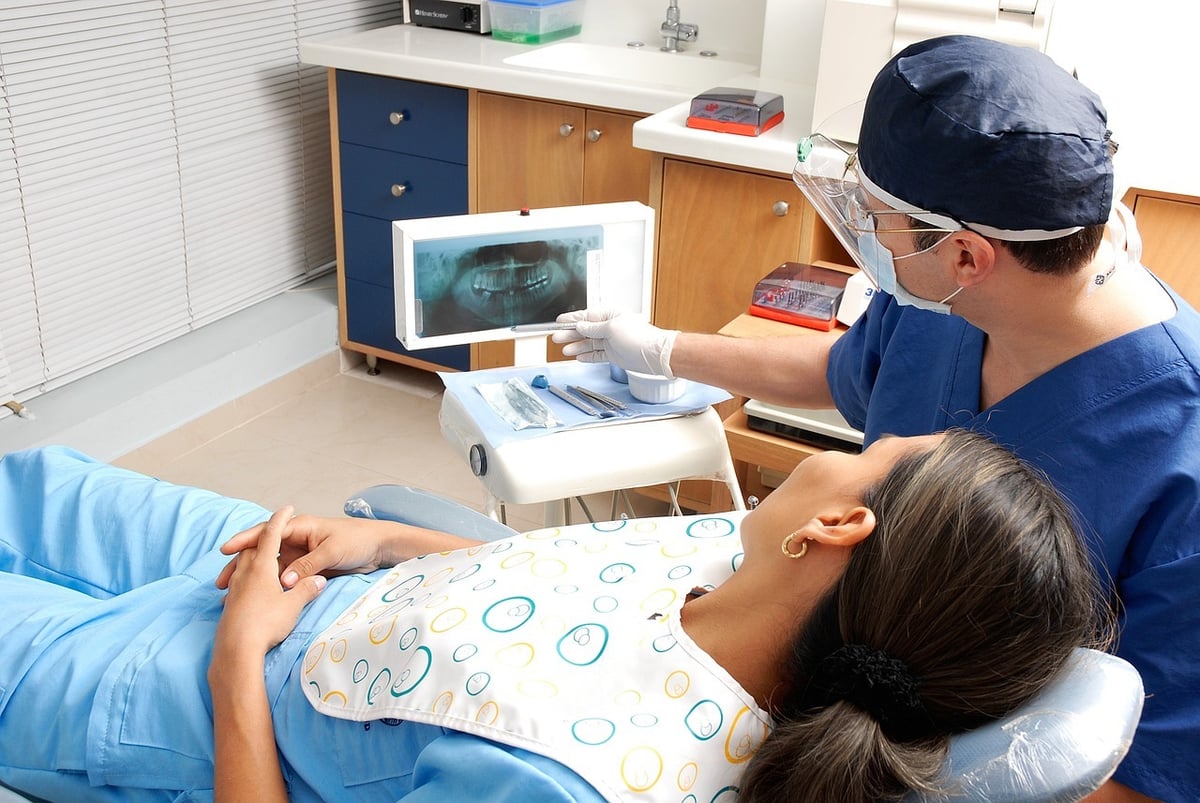 Dentista no consultorio com uma paciente