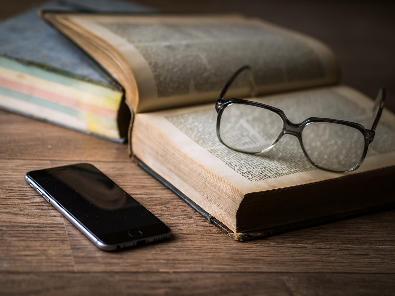 livro, óculos e celular