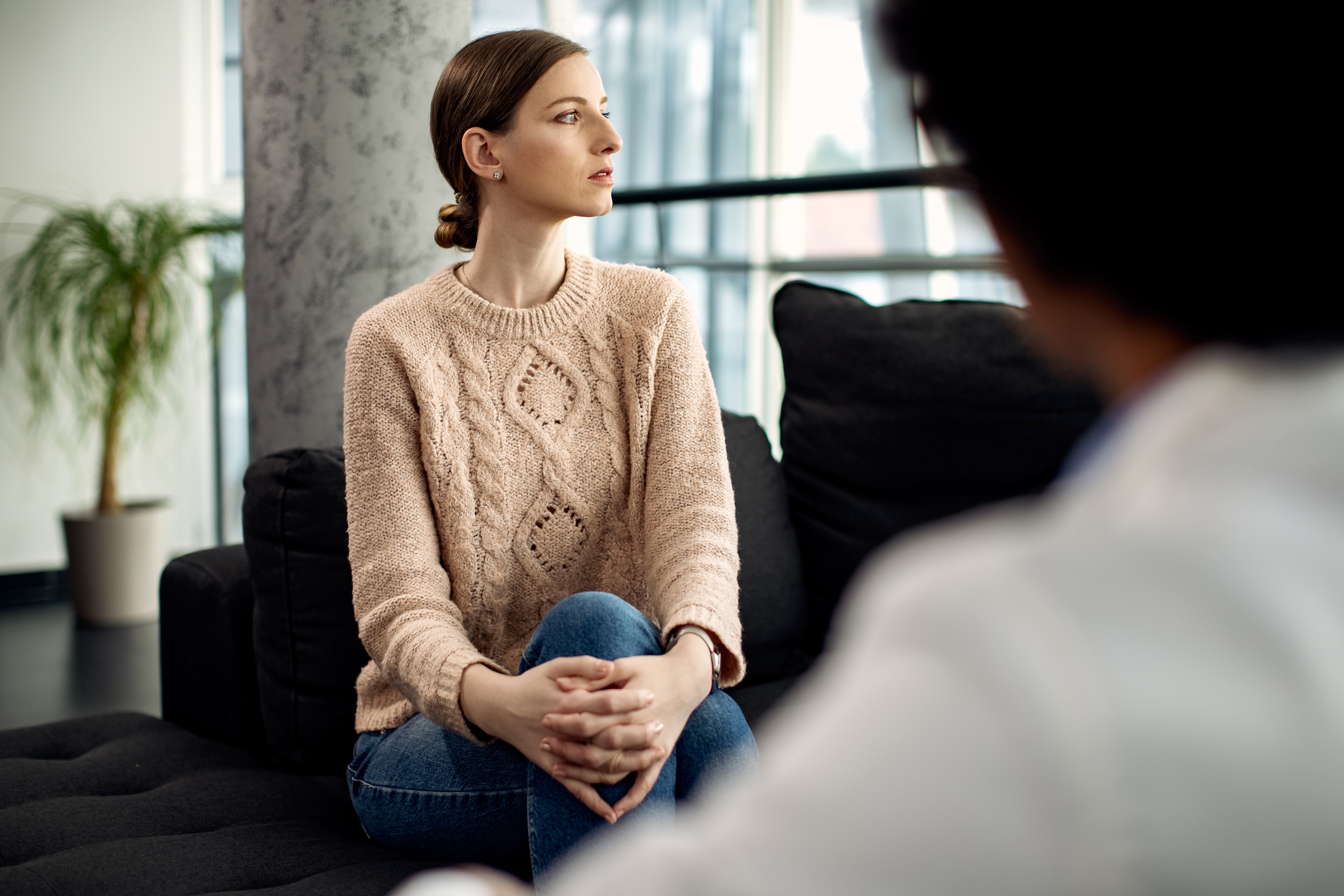 jovem mulher pensativa durante consulta psicoanálitica