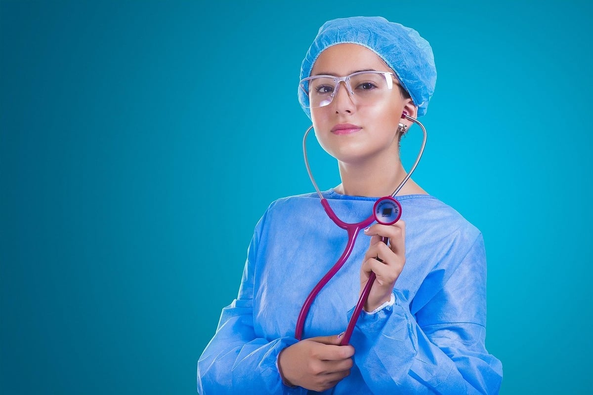 enfermeira de oculos segurando um equipamento médico